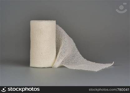 Elastic bandage for dressing wounds, on a gray background.