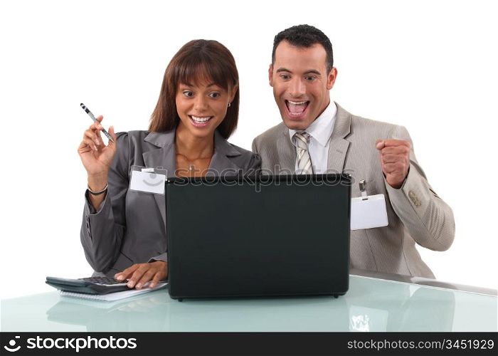 elated business duo with laptop