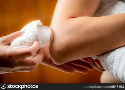 Elbow cryotherapy ice massage. Hands of a therapist placing ice directly onto a painful shoulder to relieve pain, reduce inflammation and swelling and promote healing.. Elbow Cryotherapy Ice Massage.