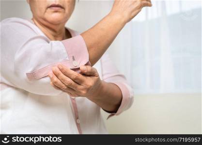 elbow pain old woman suffering from elbow pain at home, healthcare problem of senior concept