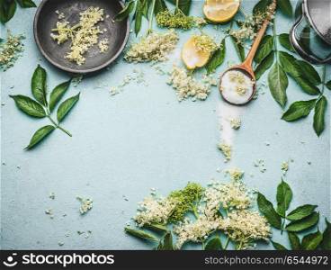 Elder flowers cooking preparation. Elder flowers with spoon, sugar and lemon on blue table background, top view