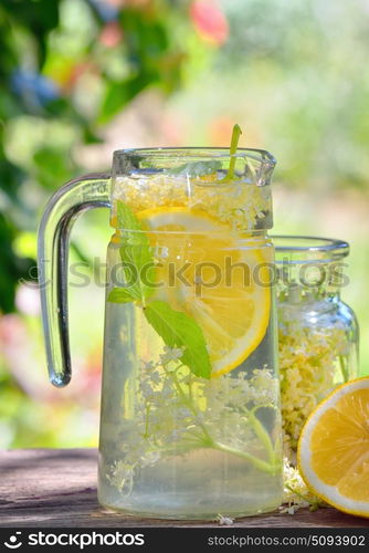 Elder lemonade with lemon on old table wood. Elder lemonade with lemon