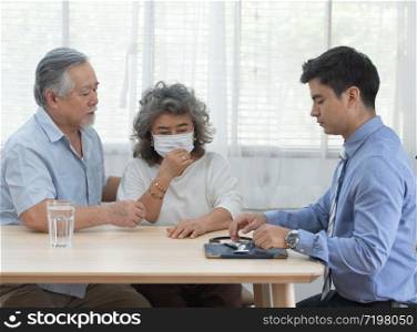 Elder senior old asian couple meeting specialist professional caucasian doctor visit at home consultant two retirement patient after checkup,health care and medical concept.. elder asian grandparent meeting doctor visit home
