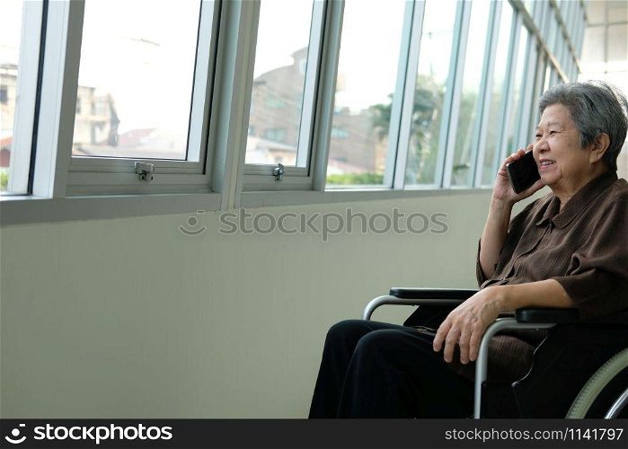 elder woman in wheelchair talk on mobile phone. elderly female speaking on smartphone. asian senior have phone conversation