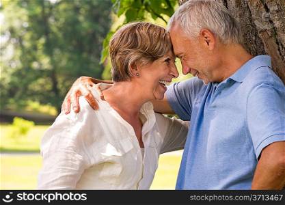 Elderly Caucasian couple laughing head to head