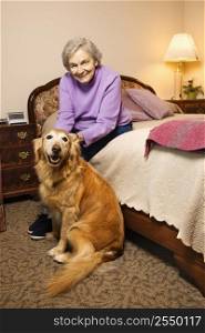 Elderly Caucasian woman and dog in her bedroom at retirement community center.