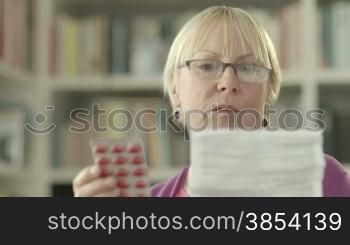 Elderly caucasian woman with medicine and reading drug prescription. Tilt shot
