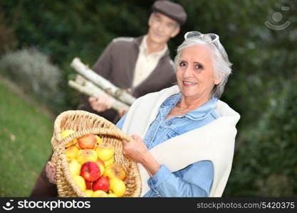 Elderly couple collecting objects in the forest