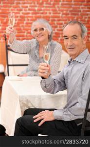 Elderly couple drinking champagne