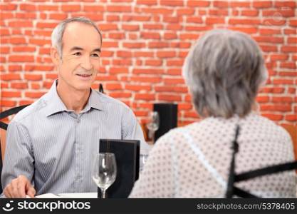 Elderly couple having meal in restaurant