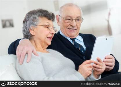 elderly couple holding a tablet