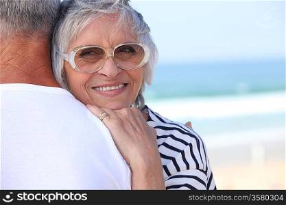 Elderly couple hugging on beach