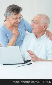 elderly couple in front of a laptop