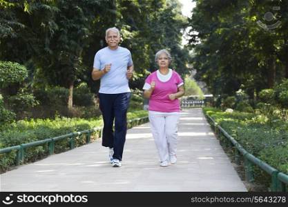 Elderly couple jogging in park
