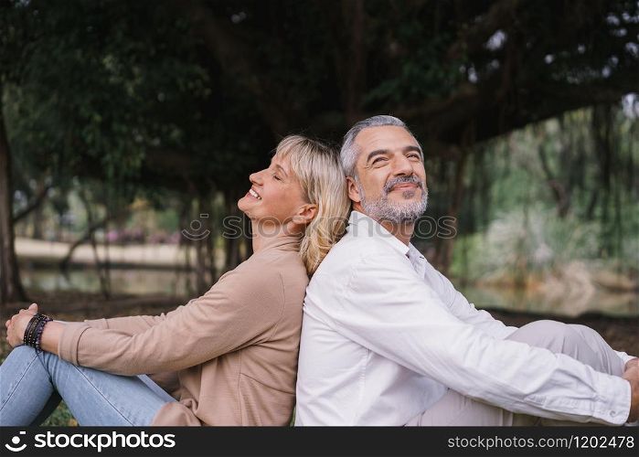 Elderly couple of sitting back to back relax together in the public park. Happy concept of lifestyle in the retirement