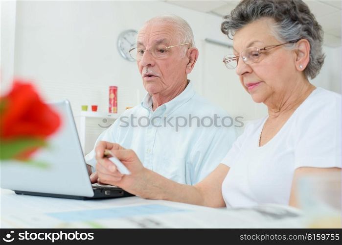 Elderly couple on computer, wife holding credit card