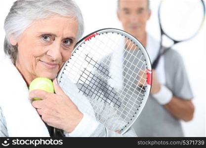 Elderly couple playing tennis