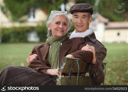 Elderly couple sat on a park bench