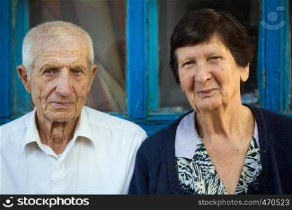 Elderly couple sitting at the front of rural house