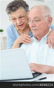 elderly couple using a laptop
