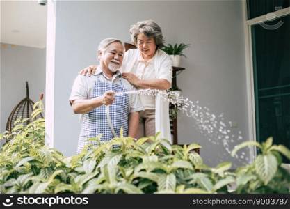 Elderly couple watering a flower in home garden