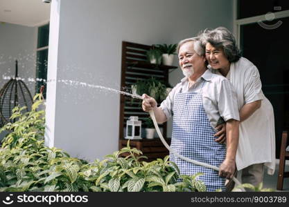 Elderly couple watering a flower in home garden