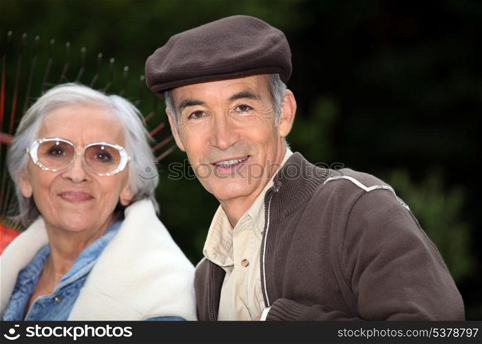 Elderly couple with garden rake
