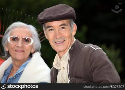 Elderly couple with garden rake
