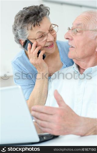 elderly couple with laptop and smartphone