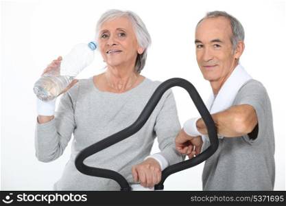 Elderly couple working out together in gym