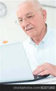 Elderly gentleman using a laptop