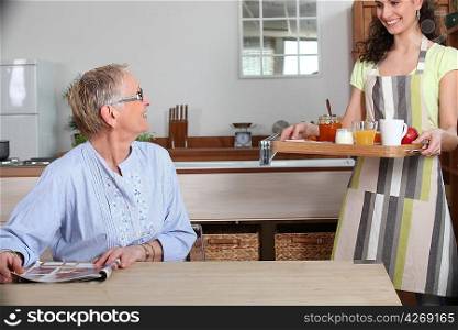 Elderly lady being brought breakfast