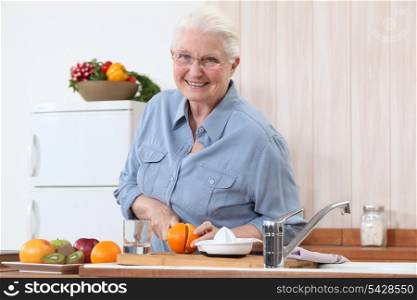 Elderly lady cutting an orange