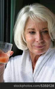 Elderly lady drinking fruit juice