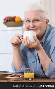 Elderly lady enjoying cup of tea