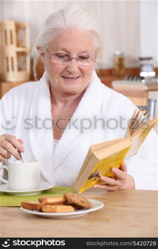 Elderly lady enjoying tea and biscuits
