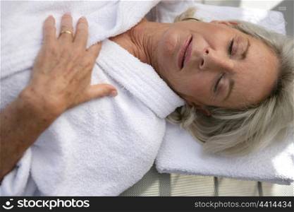 Elderly lady in bath robe having a nap