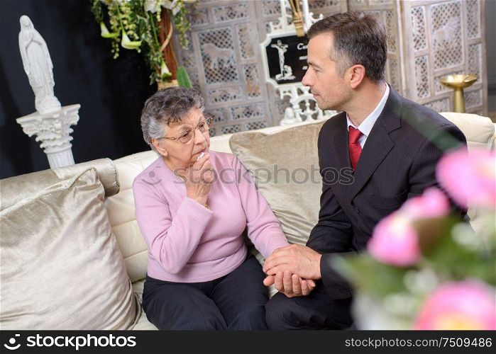 Elderly lady in chapel of rest with suited young man