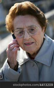 Elderly lady making call outdoors