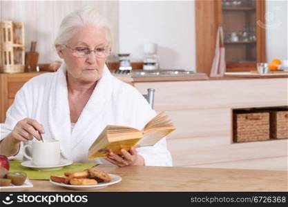 Elderly lady reading over breakfast