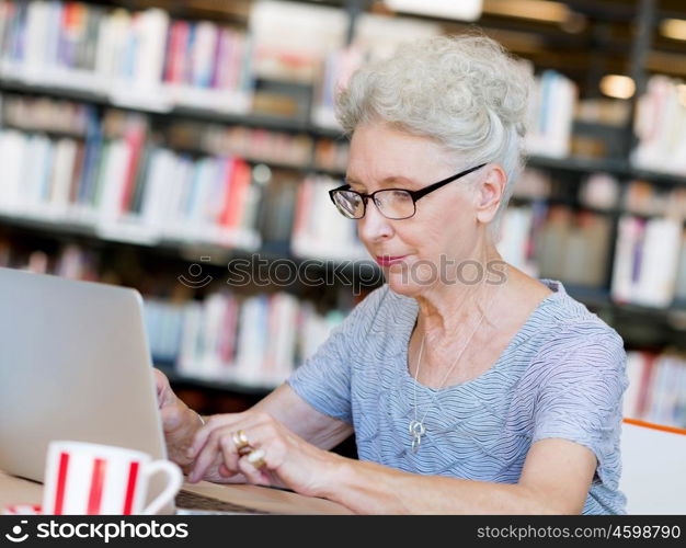 Elderly lady working with laptop. Learning new technologies