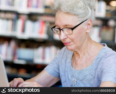 Elderly lady working with laptop. Learning new technologies