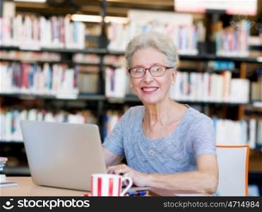 Elderly lady working with laptop. Learning new technologies