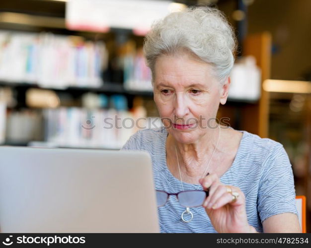 Elderly lady working with laptop. Learning new technologies