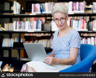 Elderly lady working with laptop. Learning new technologies