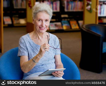 Elderly lady working with tablet. Learning new technologies