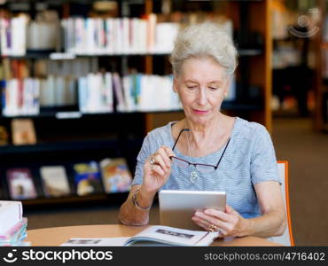 Elderly lady working with tablet. Learning new technologies