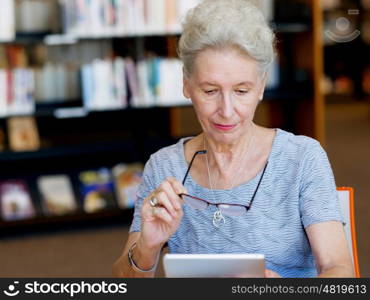 Elderly lady working with tablet. Learning new technologies