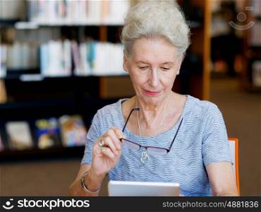 Elderly lady working with tablet. Learning new technologies