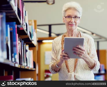 Elderly lady working with tablet. Learning new technologies